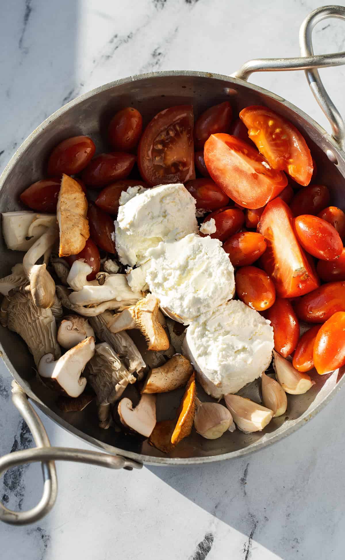 tomatoes mushrooms and goat cheese in skillet